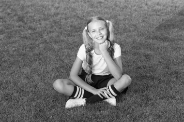 Mutlu gülümseyen öğrenci. Kız at kuyruğu saç modeli rahatlayın keyfini çıkarın. Neşeli kız öğrenci. İyi eğlenceler. Kız sevimli çocuk yeşil çim oturup. Sağlıklı duygusal mutlu çocuk açık havada rahatlatıcı. Çocuğu mutlu eden nedir?