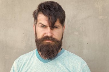 Gür bıyık harika. Şık bıyık şeklinde sakallı adam. Tıraşsız yüzünde dokulu bıyık saçlı acımasız hipster. Gri duvara uzun sakal ve bıyık giyen ciddi adam