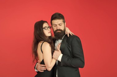 Bu gece dans edelim. Aşk ihale sarılmak kırmızı arka plan dans zarif çift. Kalbin ritmini hisset. Birlikte mutlu. Smokinli adam ve partide dans eden kadın siyahi elbise. Tutkulu çift dans