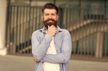 Sakalına berber lazım. Kentsel arka plan üzerinde mutlu berber. Şekilli sakallı ve bıyıklı saçlı sakallı adam berber ziyaretinden önce veya sonra gülümsüyor. Mens berber ve berber dükkanı