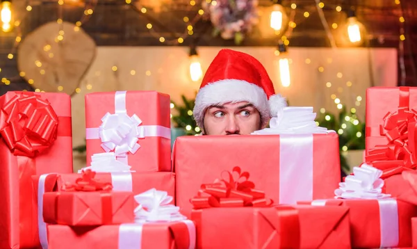 Vakantie gevuld met plezier. Man Kerstman hoed gluurt uit stapel geschenken. Kerstman met geschenken. Baard kerstman en veel vakantiepakketten. Beste prijzen voor de winter geschenken. Seizoensgebonden aanbod. Kerstverkoop — Stockfoto