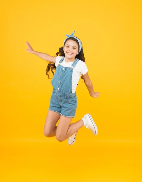 Salto de felicidad. niña pequeña salto fondo amarillo. lleno de energía. Chica activa sentir la libertad. Diversión y relax. sentirse libre. niño despreocupado en vacaciones de verano. Es hora de divertirse. belleza retro en el aire —  Fotos de Stock