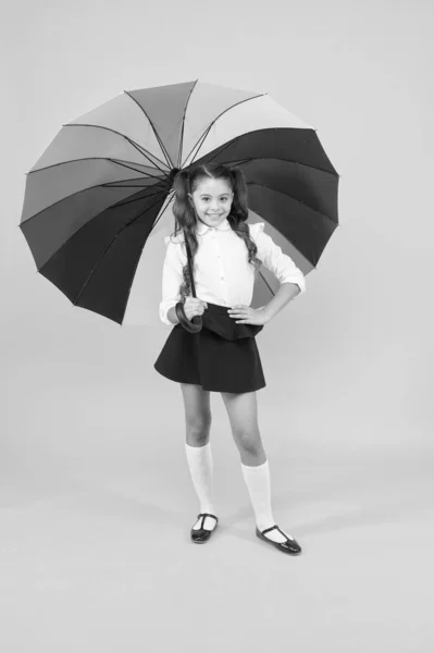 Залишайтеся сухими. Дивовижна школярка. Дівчина з парасолькою. Дощовий день. Щасливе дитинство. Стиль веселки. Малюк щасливий парасолькою. Осінній прогноз погоди. Модний аксесуар. Дощ у вересні. Аксесуар для дощового дня — стокове фото