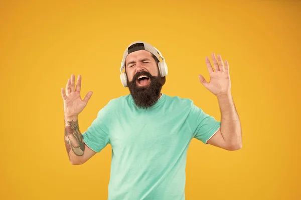 Son disco. Homme barbu relaxant avec un son mélodieux sur fond jaune. Hipster portant des écouteurs jouant du son électronique. Brutal gars écoute la bande son dans casque — Photo