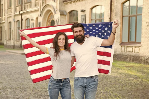 Patriotic spirit. Independence day. National holiday. Bearded hipster and girl celebrating. 4th of July. American tradition. American patriotic people. American citizens couple USA flag outdoors