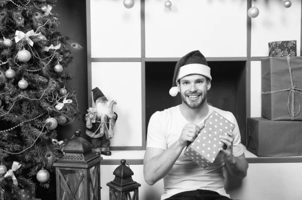 Santa sonrisa del hombre con caja de regalo en el árbol de Navidad — Foto de Stock