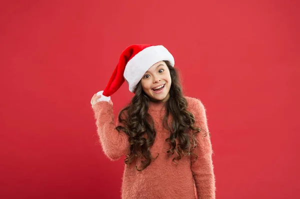 Conceito de convite de Natal. Bonitinho brincalhão. Menina adorável com cabelos longos encaracolados usar Papai Noel chapéu fundo vermelho. A contar dias até ao Natal. Festa de Natal para crianças e estudantes — Fotografia de Stock