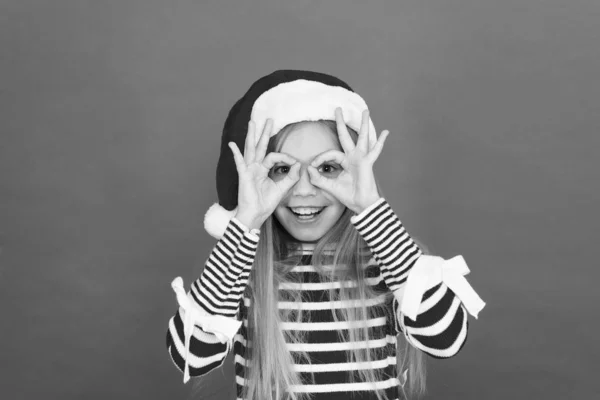 Fiesta divertida. Niño feliz hacer gafas gesto fondo rojo. Niña, disfruta de la fiesta de Santa Claus. Fiesta de Nochevieja. Únete a nosotros para la fiesta de Navidad. Celebra la temporada festiva. Celebraciones navideñas — Foto de Stock