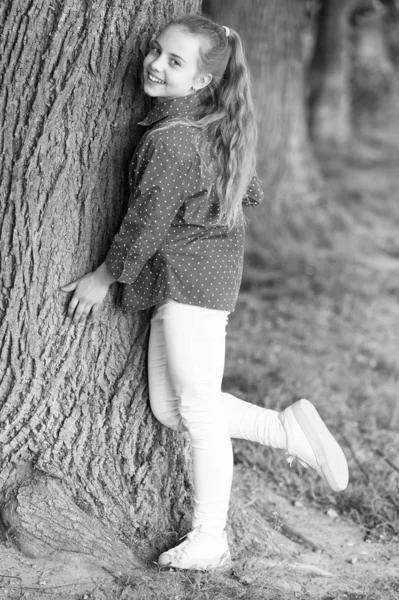 그녀는 정말 귀엽다. 패션 리틀 레이디. 나무에서 캐주얼 패션 스타일의 세련된 아이. 여름 날에 캐주얼 웨어에 패션의 사랑스러운 소녀. 작은 유행 모델의 패션 룩 — 스톡 사진