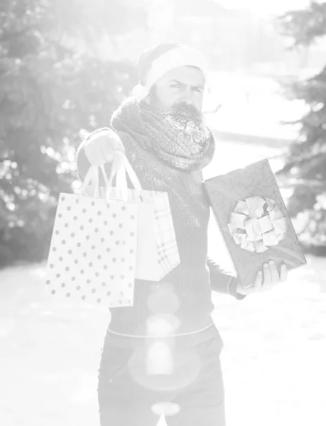 Handsome santa man with gift on bright sunny winter day outdoors on natural background — ストック写真