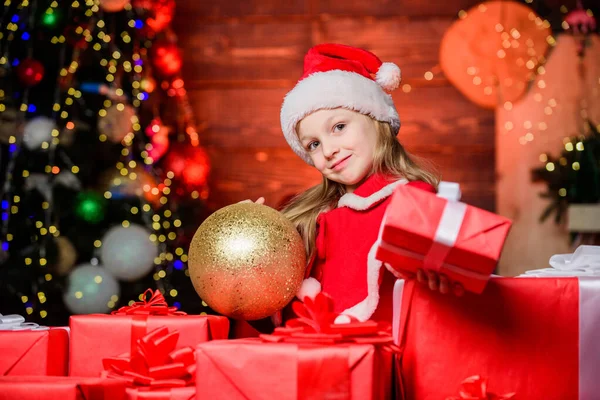 Різдвяний подарунок для вас. Щаслива маленька дівчинка дарує подарунок на Новий рік. Маленька дитина тримає подарункову коробку в день боксу. Чарівна дитина з красиво загорнутим різдвяним подарунком. Загорнути його дуже гарно — стокове фото