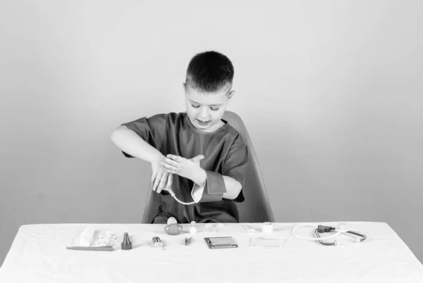 Concepto de medicina. Examen médico. Educación médica. Juega a juego. Niño lindo niño futuro médico carrera. Vida sana. Salud. Pequeño doctor sentado mesa con estetoscopio y herramientas médicas — Foto de Stock