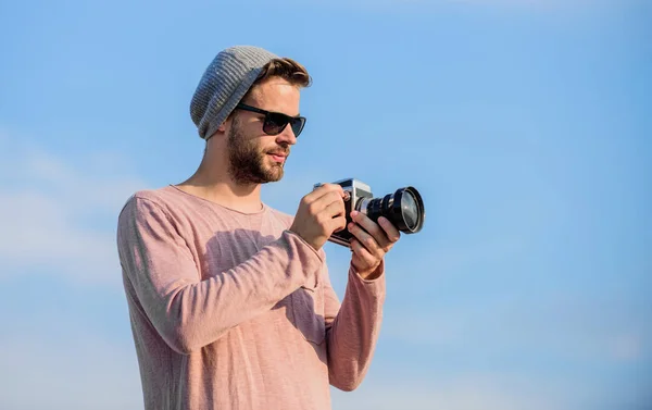 Concept de photojournaliste. Guy photographe en plein air ciel arrière-plan. Un reporter de Hipster qui prend des photos. Réglages manuels. Blogueur de voyage. Photographe professionnel. Beau photographe gars appareil photo rétro — Photo