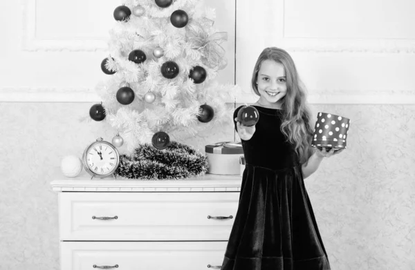 Tradiční rodinná dovolená. Kid dívka poblíž vánoční strom drží krabičky. Dítě doma slaví Vánoce. Oblíbený den v roce. Doba nutná k otevření vánoční dárky. Otevření vánoční dárky — Stock fotografie