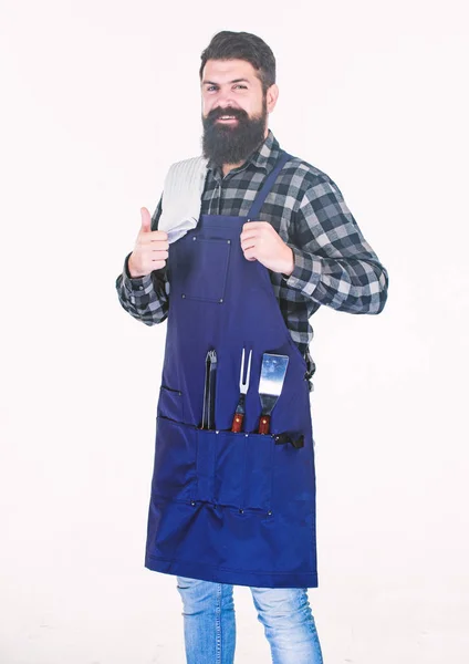 Feliz y satisfecho. Chef hipster dando pulgares arriba. Brutal hipster con delantal de barbacoa con herramientas de parrilla en los bolsillos. hipster barbudo listo para preparar alimentos a la barbacoa. Cocinero hipster profesional —  Fotos de Stock