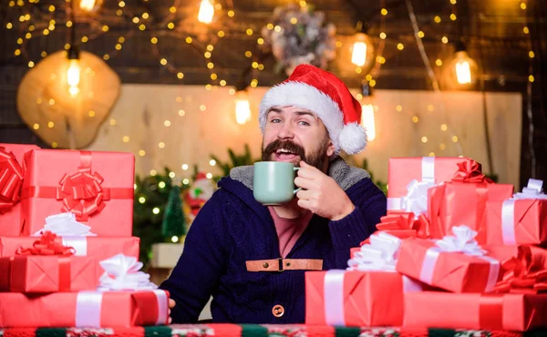 xmas present and gift. boxing day. hot tea in cold winter. winter holidays. happy new year. christmas time. bearded man santa hat. man drink hot milk. Christmas Shopping