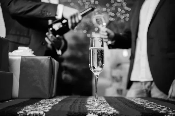 Nieuwjaar traditionele kenmerk. Gelukkig nieuw jaar en merry christmas. Champagne elegante glazen. Glas gevuld mousserende wijn of champagne in de buurt van geschenkdozen. Nieuwjaar corporate. Glas champagne close-up — Stockfoto