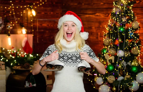 Inverno activo. Chapéu de Pai Natal com patins artísticos. Menina alegre com par de patins. Patinador presente de Natal. Feriados de Natal divertidos de inverno. Desportos de Inverno. Ideias para o lazer. Equipamento esporte ao ar livre — Fotografia de Stock