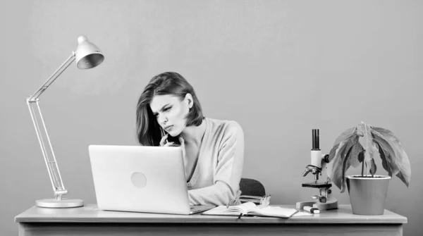 Primer plano de la discusión. mujer con microscopio. mujer trabaja en la oficina en el portátil. Una mujer de negocios hablando por teléfono. secretaria de usar el teléfono móvil en el lugar de trabajo. datos e información. Comunicación empresarial — Foto de Stock