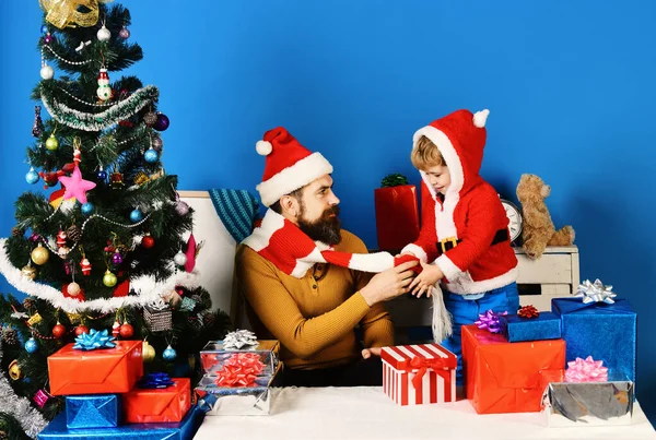 Familia de Navidad abre regalos sobre fondo azul. —  Fotos de Stock