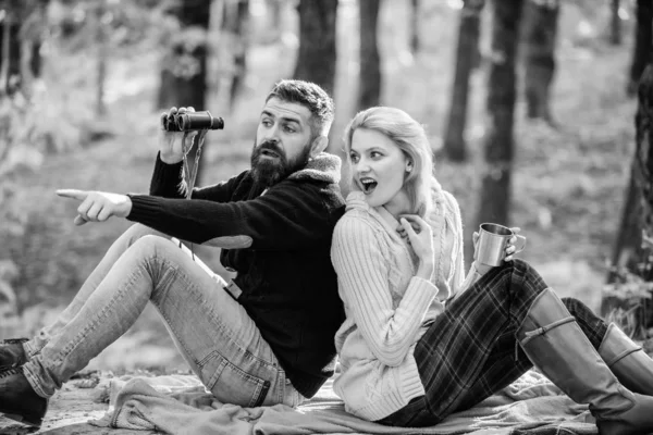 Selvagem ao ar livre. casal apaixonado relaxar na floresta de outono com chá ou café. acampar e caminhar. menina surpresa beber vinho quente. homem barbudo chocado relógio com binóculos. Humor de primavera. Piquenique familiar — Fotografia de Stock