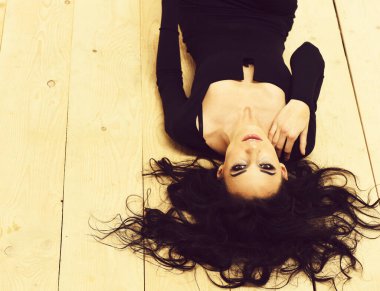 Tahta arka planda siyah elbiseli seksi kız.