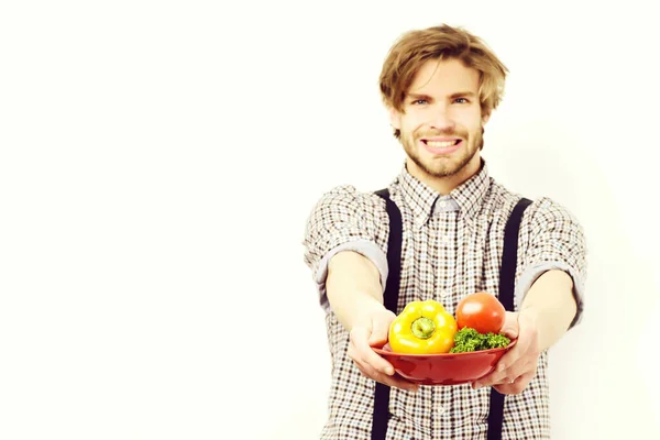 Agricultor con tazón rojo de verduras frescas aisladas en blanco — Foto de Stock