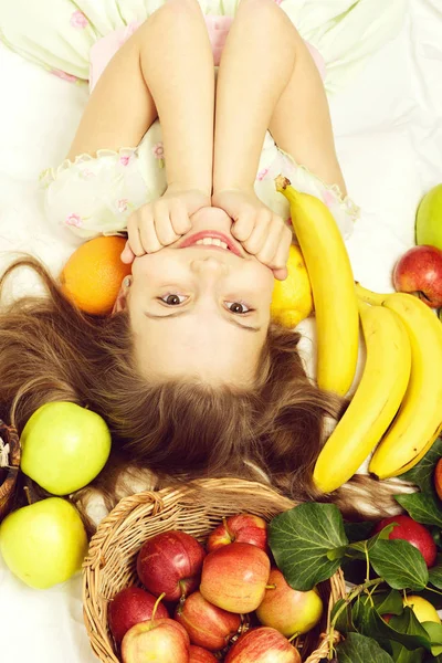 Μικρό χαρούμενο κορίτσι τρώει εξωτικά φρούτα ή καλοκαιρινό φόντο — Φωτογραφία Αρχείου