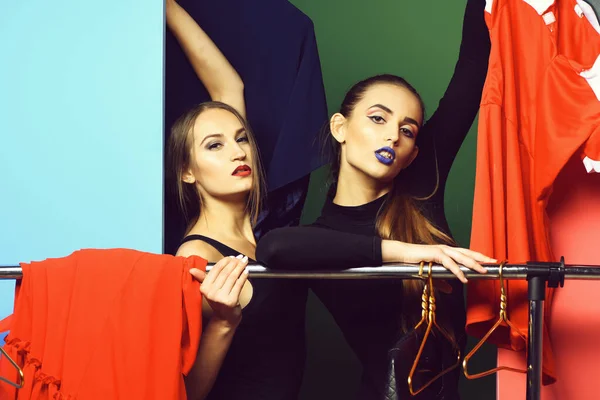 Twee mooie meisjes winkelen bij kledingrek — Stockfoto