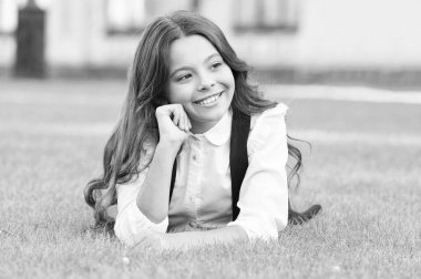 Tatiller eğlencelidir. Mutlu küçük çocuklar okul tatillerinin tadını çıkarın. Küçük kız tatil zamanı yeşil çimlerde dinlenir. Her gün. Tatil ya da okul tatili. Tatil