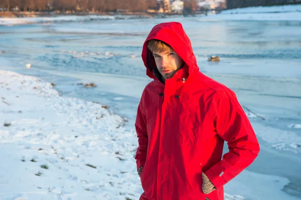 Kırmızı parkalı adam. Kış erkek modası. Soğuk iklim için sıcak kıyafetler. Hava tahmini. İnsan ve doğa. Adam gün batımında karlı arazide yürüyor. seyahat ve keşif konsepti — Stok fotoğraf