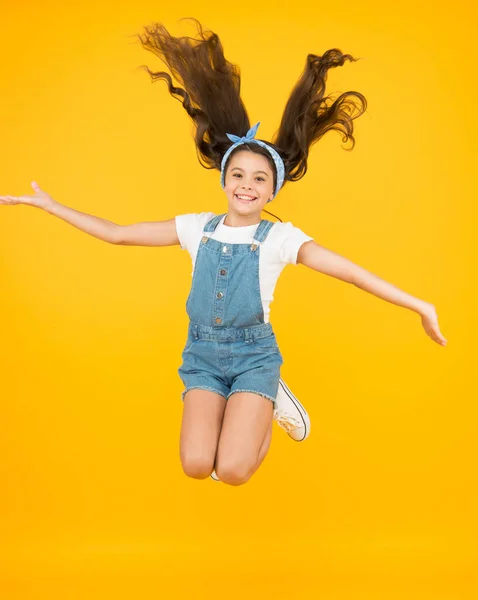 Menina pequena saltar fundo amarelo. cheia de energia. Menina ativa sentir a liberdade. Diversão e relaxe. sentir-se livre. criança despreocupada nas férias de verão. Está na hora da diversão. beleza retro no ar. Salto de felicidade — Fotografia de Stock