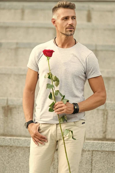 Pouco romance pode melhorar a sua vida amorosa. Homem macho maduro com presente romântico. Um tipo bonito com um encontro romântico de flores cor de rosa. Dia dos namorados e aniversário. Entrega de flores. Cavalheiro romântico — Fotografia de Stock