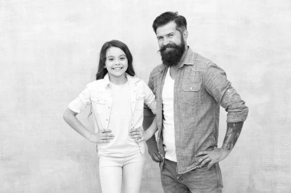 My father is hipster. Happy hipster and little girl on grey background. Bearded hipster and small child smiling in casual style. Caucasian hipster and his adorable daughter