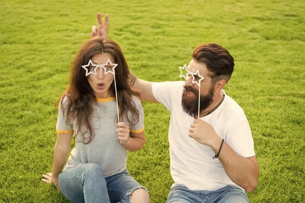 Gek in liefde. Sensuele vrouw en bebaarde man in gekke stemming ontspannen op groen gras. Gek paar plezier met partij rekwisieten. Speels en gek gevoel — Stockfoto