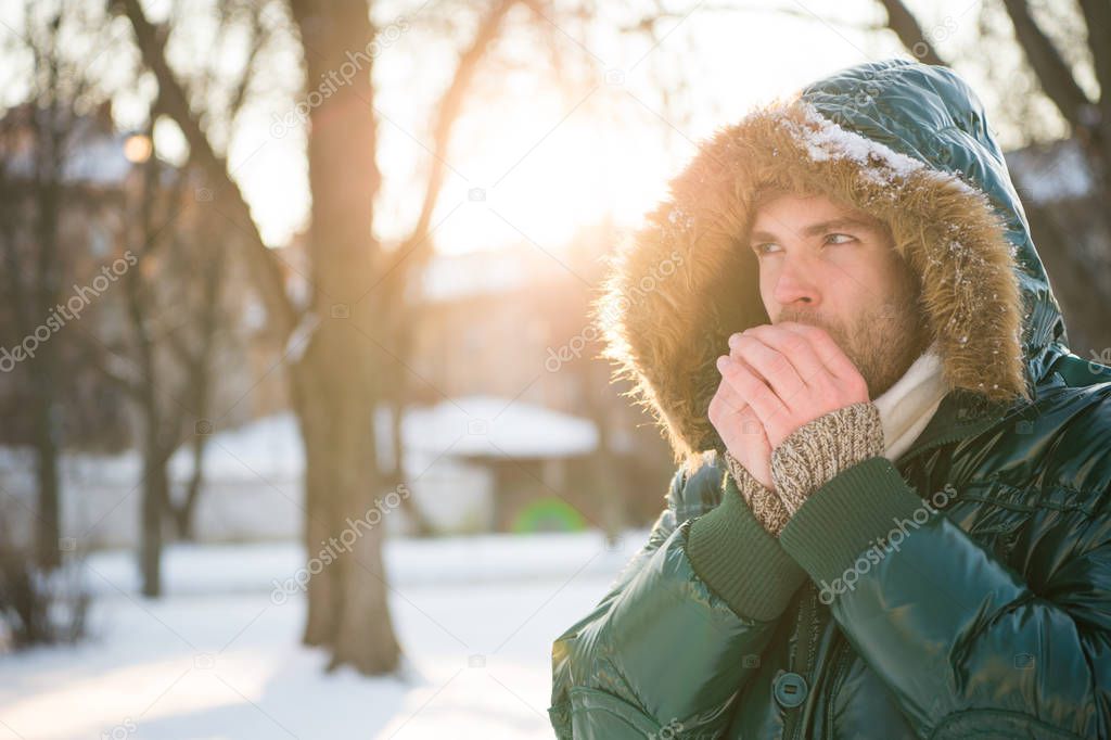 cold and loneliness. male in down coat with fur hood. feel warm and comfortable. favorite season. guy green puffer coat. man enjoy winter landscape. nature is beautiful. place for thoughts