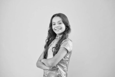 Yeni görünüşüne bayılıyor. Şirin küçük bir çocuğun uzun kıvırcık saçlı Çinli görünüşü var. Moda mankeni modası. Pembe arka planda mutlu bir kız