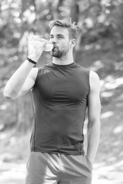 Bebida refrescante. Hombre deportista atlético mantenga la botella de agua. Hombre atleta ropa deportiva se preocupan por el equilibrio del agua. Estilo de vida saludable. Atleta beber agua después de entrenar en el parque. Vitaminas y minerales — Foto de Stock