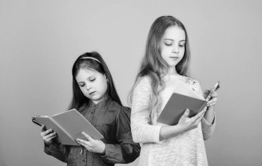 Kitaplı ya da not defteri olan çocuklar. Eğitim ve çocuk edebiyatı. En sevdiğim peri masalı. Kız kardeşler birlikte okumak için kitap seçerler. Sevimli kızlar kitapları sever. Gizli günlük. Okuryazarlık yoluyla kapıları açmak