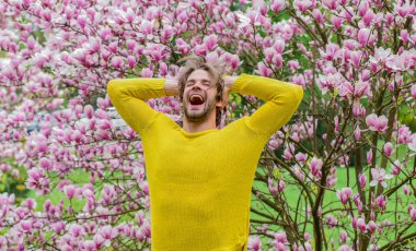 Baharın neşesi. Erkek çiçek arka planı. Bahar güzeli. Hippi çiçeğin tadını çıkarır. İlkbahar konsepti. Adam çiçek parkında rahatlıyor. Botanik bahçesi. Tazelik ve uyanış. Bahar ilham. Nisan Mayıs