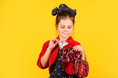 Zengin olmak için doğmuşsun. Küçük kız para çantasına dolar koydu. Küçük çocuk para biriktirir. Tasarruf. Tasarruf hesabına para yatır