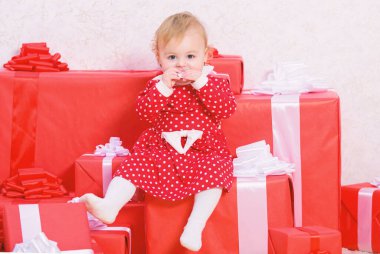 Noel'de küçük çocuklar ile yapılacak işler. Yürümeye başlayan çocuk için Noel hediyeleri. Çocuk için ilk hediyeler Noel. İlk Noel kutlaması. Küçük kız bebek hediye kutuları yığını oynamak. Aile tatilleri