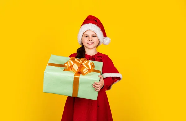 Es hora de celebrar. niño sonriente con sombrero de santa. Deja que tu Navidad sea brillante. felicidad infantil. pequeño elfo celebrar caja de regalo. la preparación de año nuevo. tiempo de compras de Navidad. tienda de juguetes y regalos para niños —  Fotos de Stock