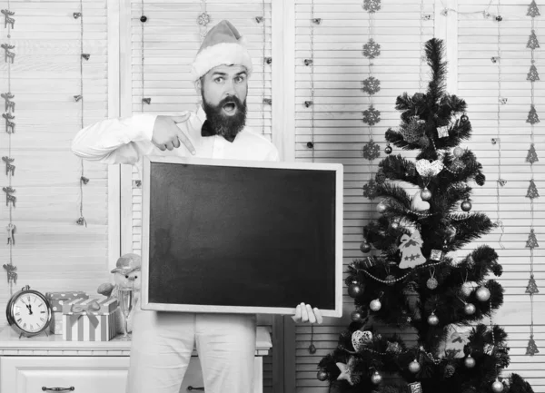 Mann mit Bart hält leere Tafel und zeigt darauf — Stockfoto