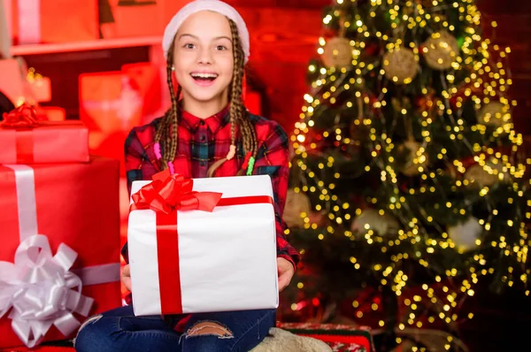 Karácsonyi hangulat. Családi nyaralás. Egy kölyök a bevásárlóközpontban. Boldog új évet! gyermek piros télapó kalapban. gyerek ajándékdobozzal. téli vásár. Varázslatos ajándékdoboz. Boldog kis mosolygós lány karácsonyi ajándékdobozzal — Stock Fotó