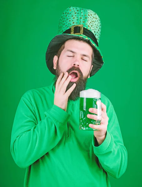 Firar saint patricks dag i ölstuga. Skäggig man skåla för att saint patricks dag. Hipster i gröna leprechaun hatt hålla ölglas. Irländska mannen med skägg dricka Grön öl. Han gäspade lycka — Stockfoto