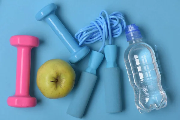 Corde à sauter, pomme et cloches à côté de la bouteille d'eau — Photo