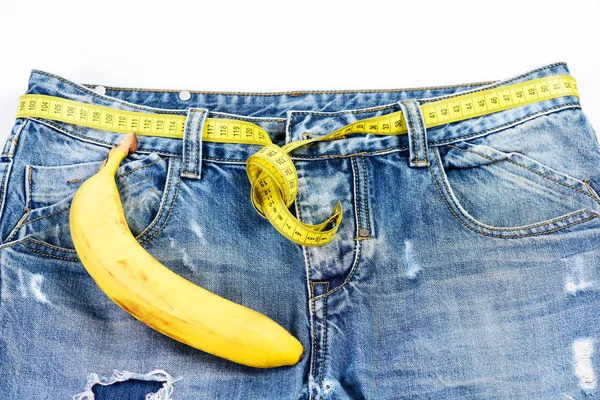 Jeans com fita métrica em vez de cinto sobre fundo branco — Fotografia de Stock