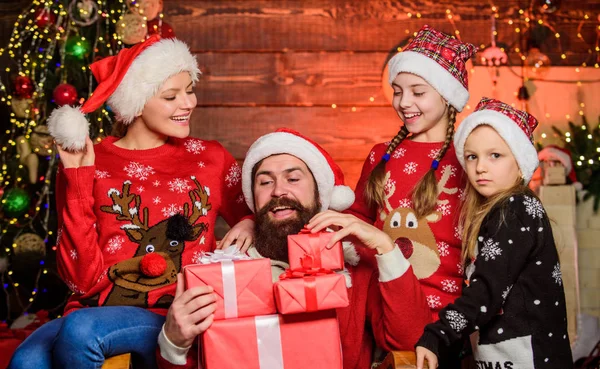 Christmas tradition. Father bearded man and mother with cute daughters christmas tree background. Happy holidays. Spend time with your family. Parents and children opening christmas gifts. Boxing day
