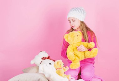 Çocuk küçük kız oynak oyuncak ayı peluş oyuncak tutun. Oyuncak ayılar psikolojik sağlığı geliştirmek. Yumuşak oyuncak ayıcık pembe arka plan ile küçük kız oyun evlat. Pelüş hayvanlar için benzersiz ekleri